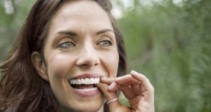 Woman putting Invisalign clear braces in her mouth